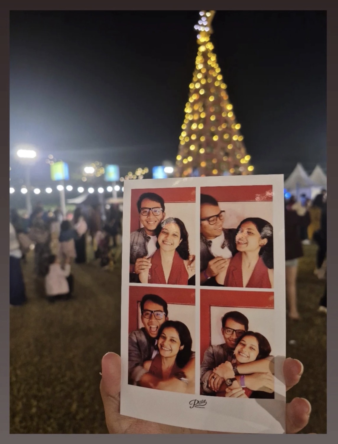 Purnanga and Sudeshna holding a photo-booth strip from a Christmas party