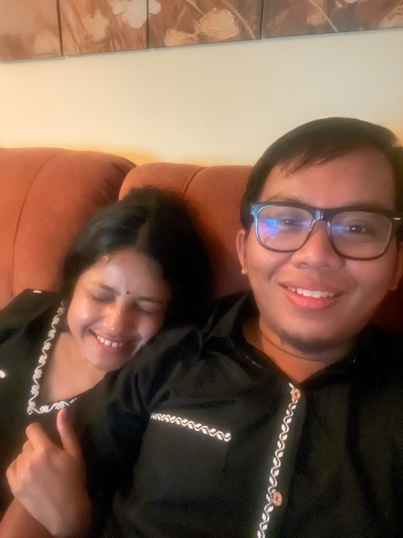 Purnanga and Sudeshna laughing together at home in traditional black outfits